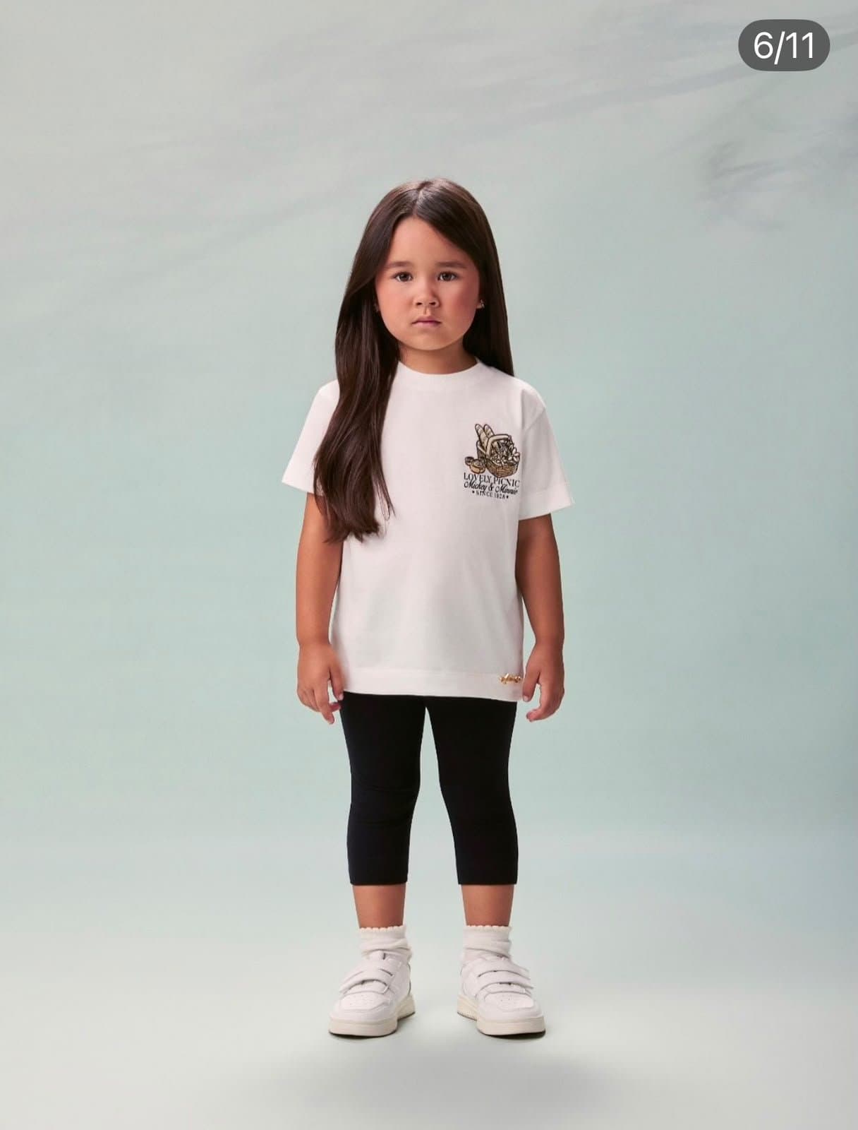 Criança pequena em camiseta branca e legging preta